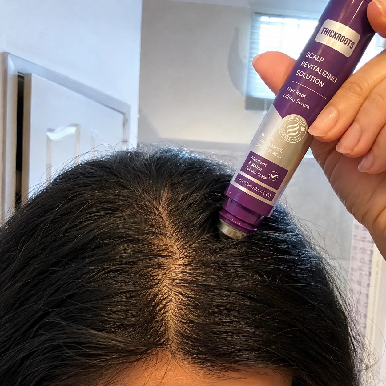 THICKROOT roll-on applicator used along the scalp part line